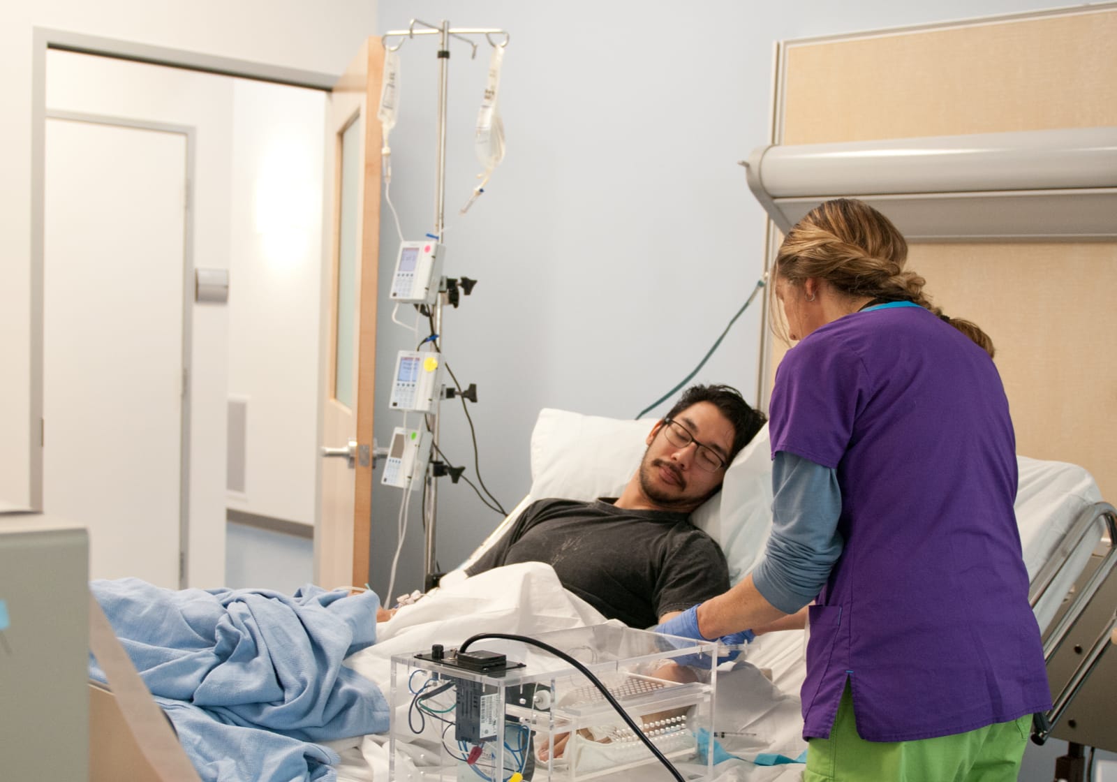healthcare professional attending to patient in hospital bed