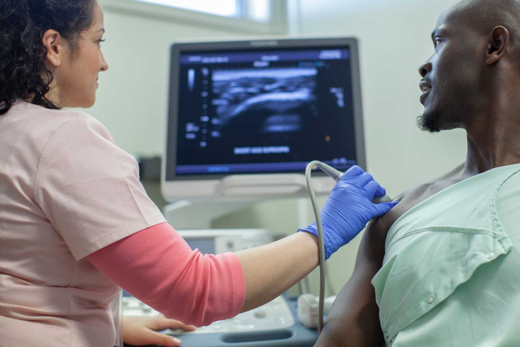 Woman taking a sonogram of a man's chest