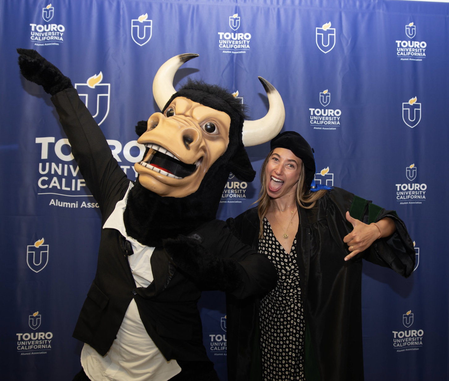 A photo shows a member of the Touro University California College of Osteopathic Medicine\'s Class of 2025 posing for a fun photo with the TUC mascot prior to a Commencement ceremony May 19 at the Sacramento Memorial Auditorium.
