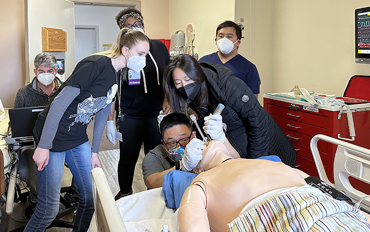 PA students engage in an exercise inside the TUC simulation lab on an airway dummy.