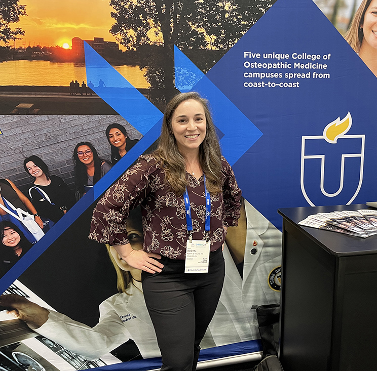 A photo shows Dr. Robyn S. Young, Touro University California Class of 2012, at the Touro University booth at the American Osteopathic Association\'s annual Osteopathic Medical Education Conference in Orlando, Florida, Saturday, Oct. 7, 2023.